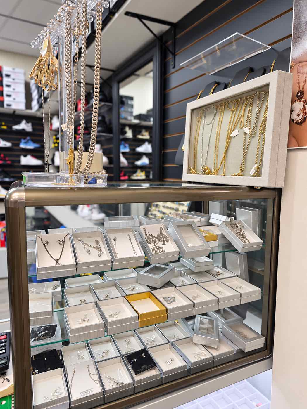 Vitrina de joyería con collares, dijes y cadenas de oro y plata